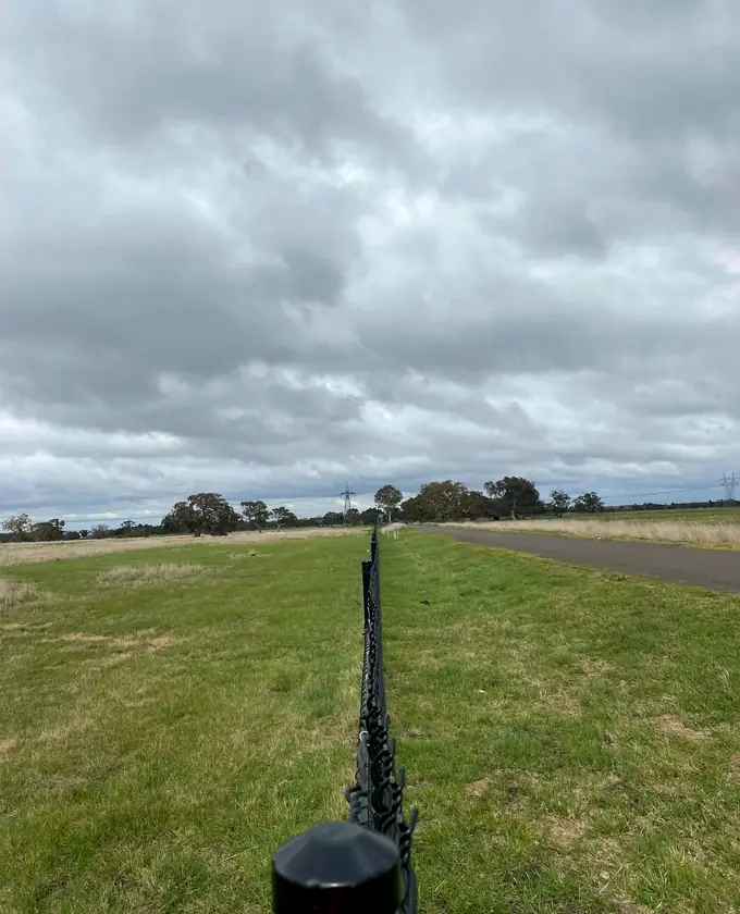 View along the top line of a black perimeter fence