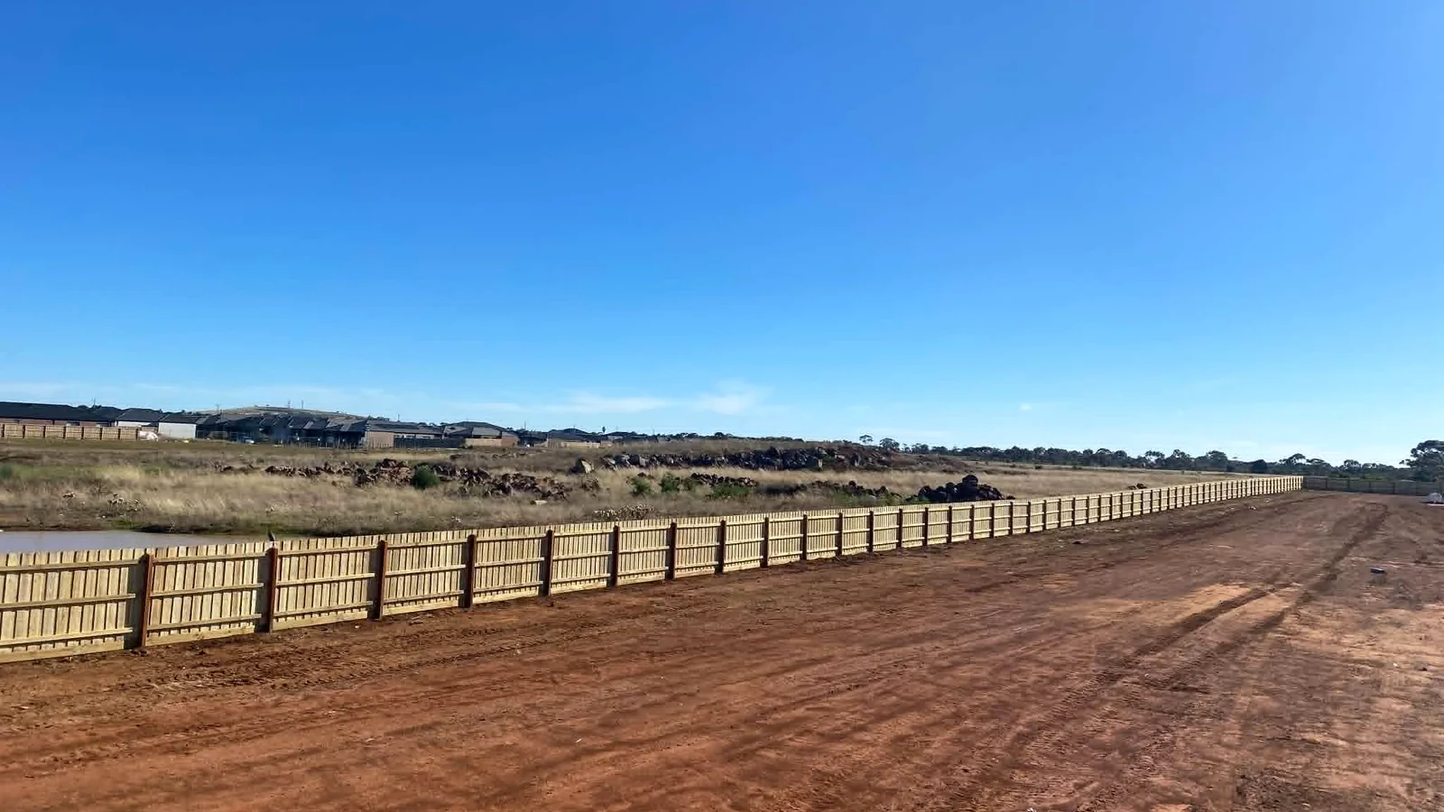 Long commercial timber fence installed across a subdivision boundary